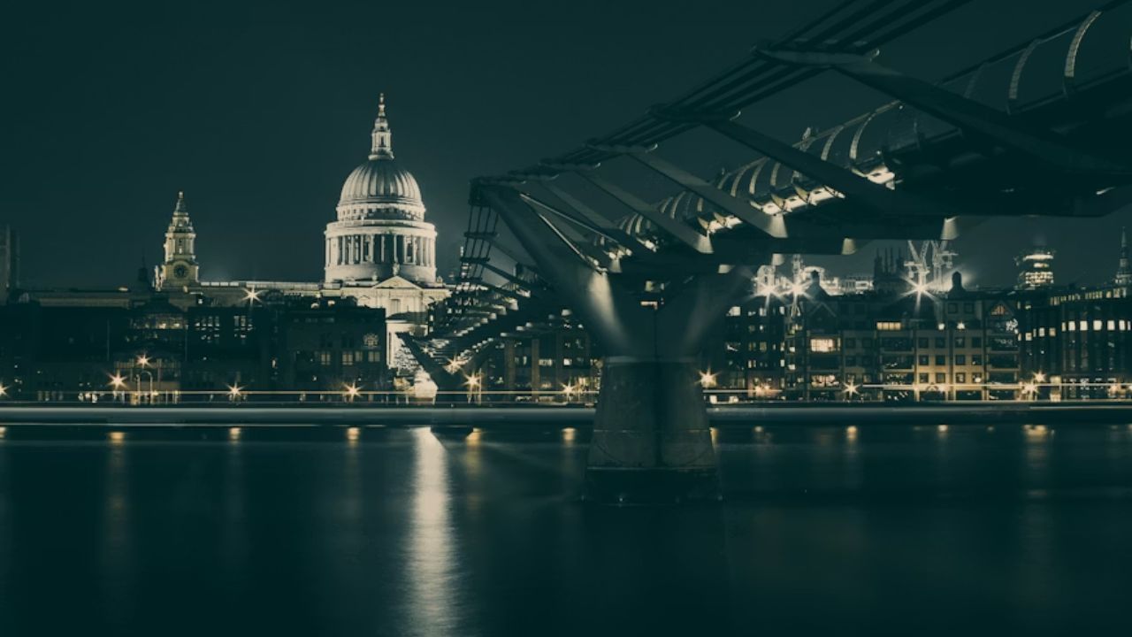 Night view of Washington DC with illuminated landmark bridge.
