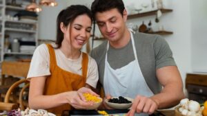 Couple preparing pizza together during cooking class.