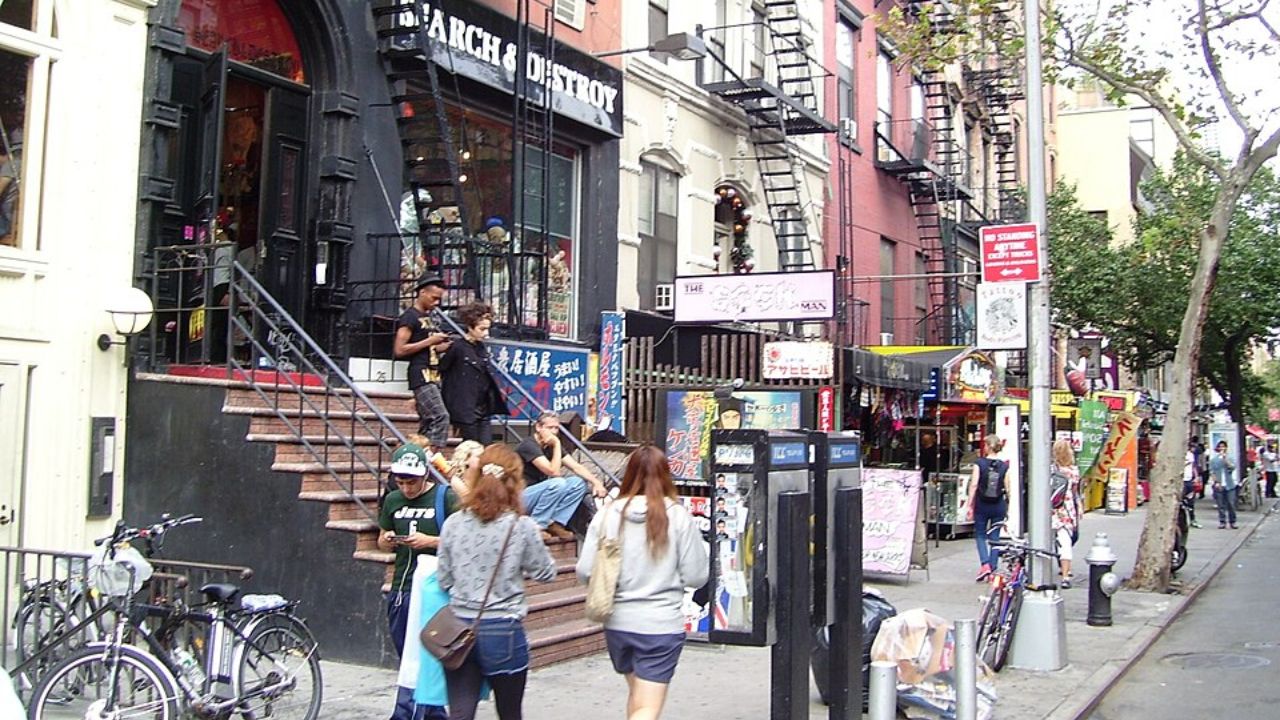 Busy St. Mark’s Place storefronts with pedestrians and bicycles.