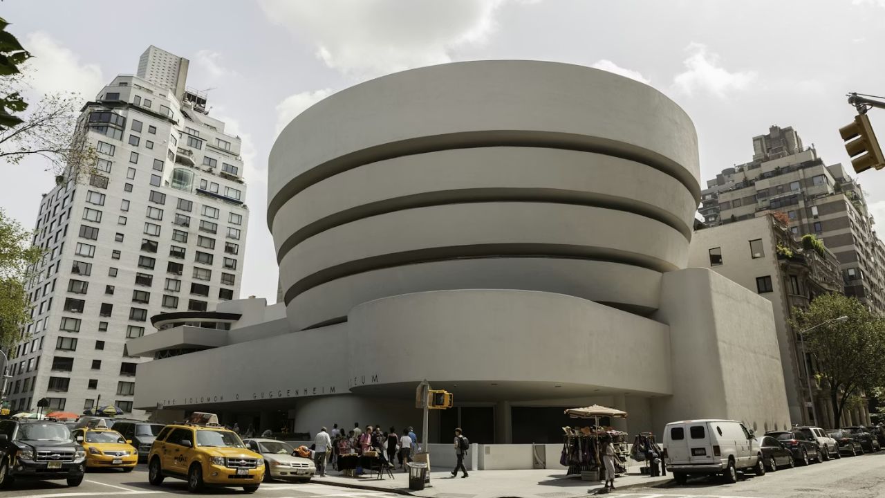 Guggenheim Museum exterior with spiral design and street activity.