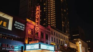 Nighttime view of Apollo Theater with neon signage.
