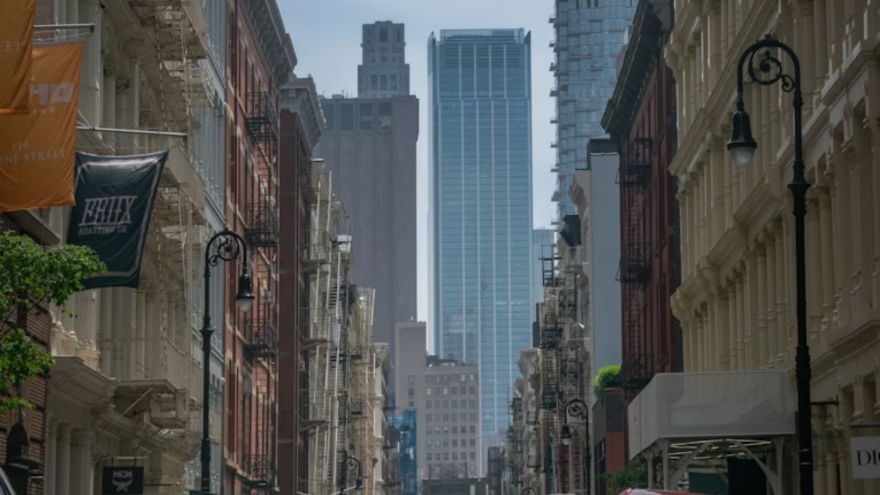 Motorcycle on cobblestone street with historic buildings and storefronts.
