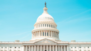 United States Capitol dome in Washington DC under blue sky.