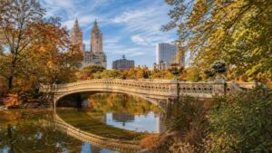 Bow Bridge in Central Park with autumn foliage skyline