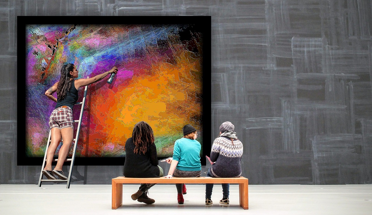 Artist painting colorful mural in gallery