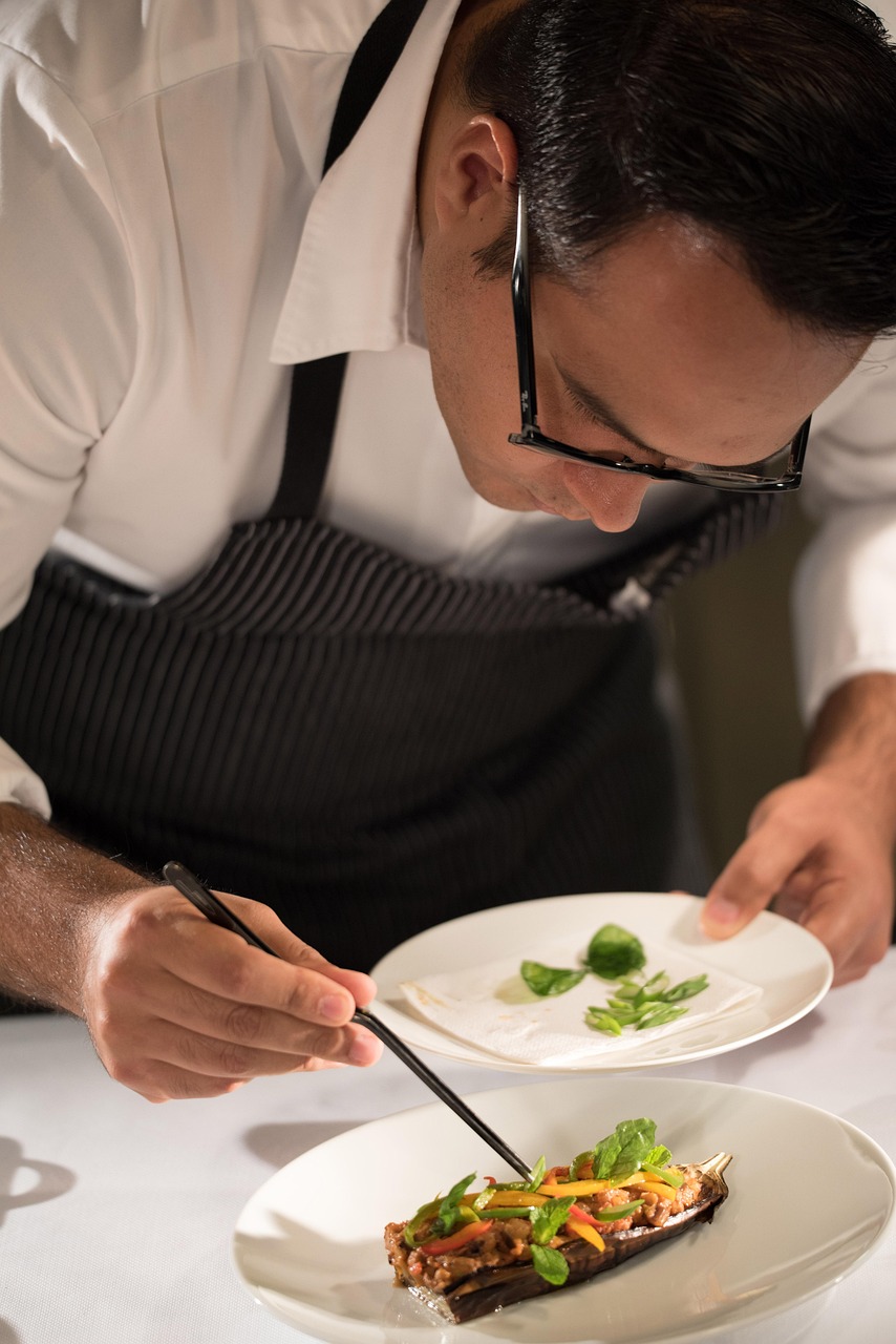 Chef carefully plating a colorful dish in restaurant kitchen