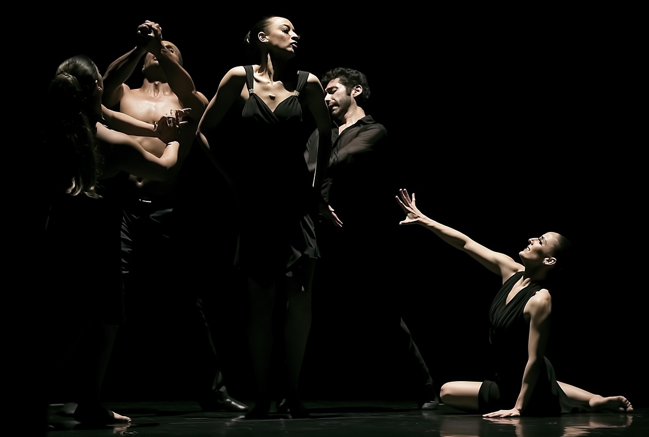 Dance performers on a dark stage