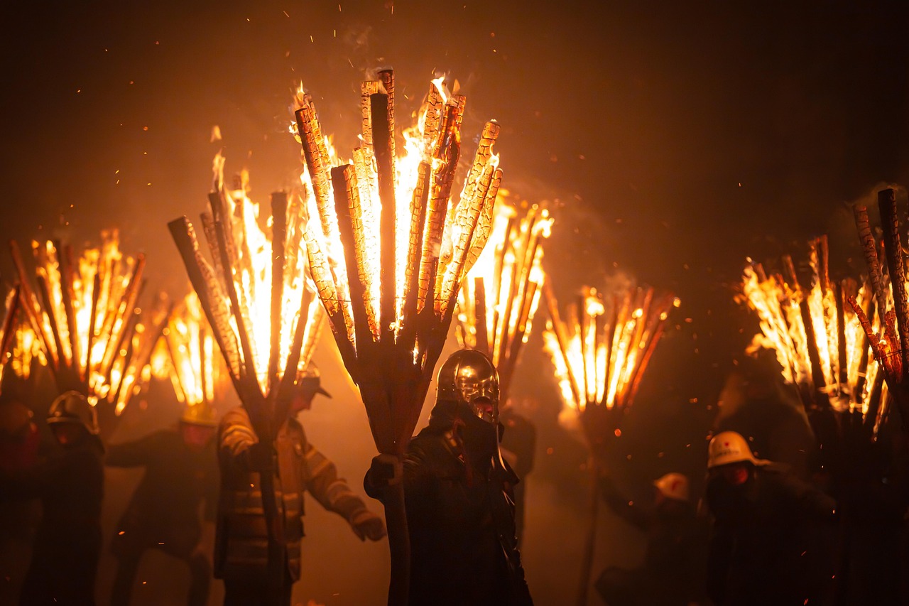 Fire festival — Costumed figures holding blazing torch bundles