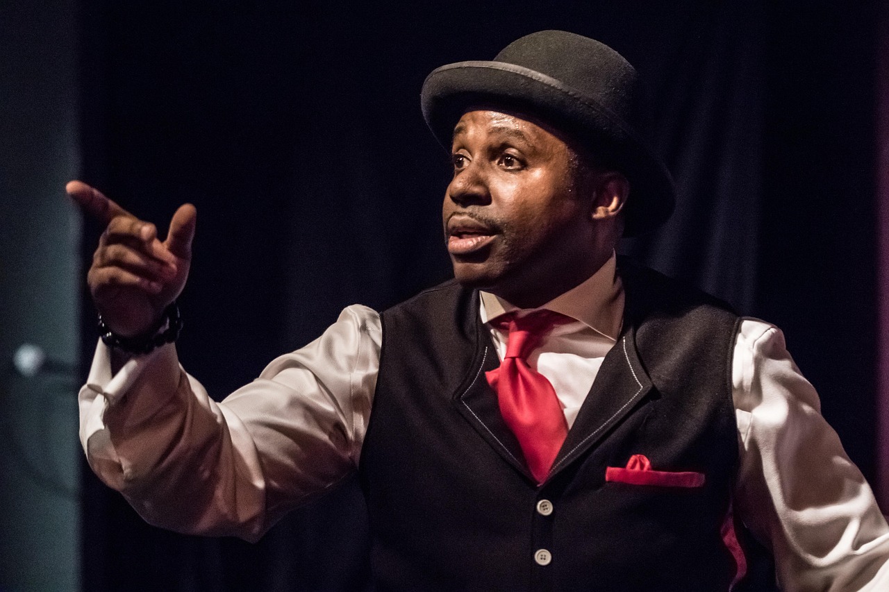 Male stage performer in bowler hat and red tie