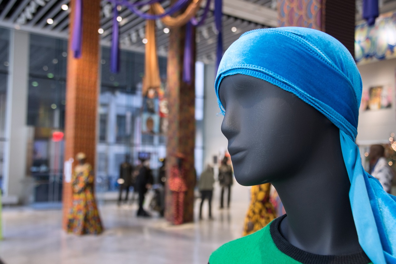 Mannequin head wearing blue head wrap in gallery