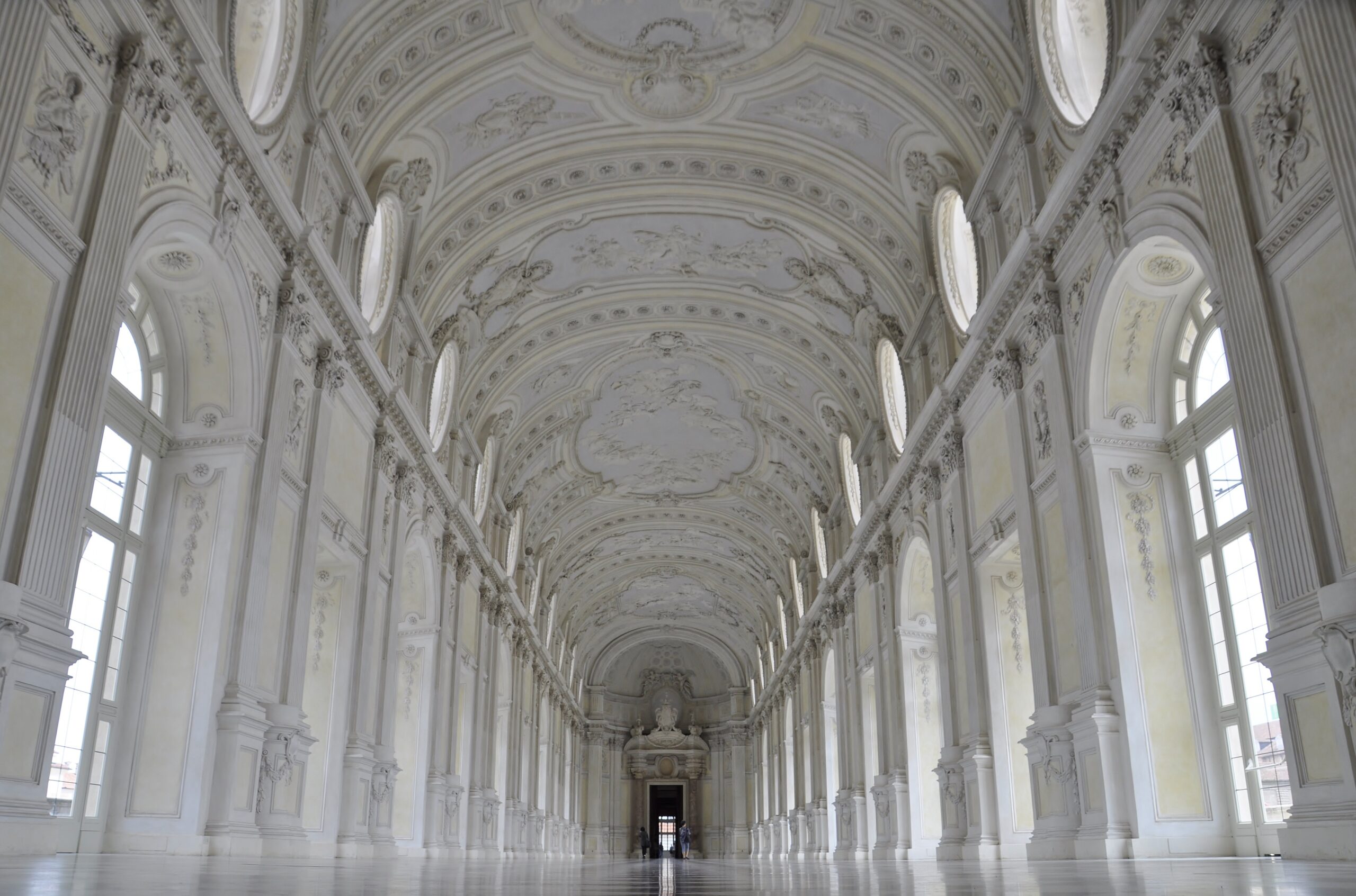 Ornate white baroque gallery hall with vaulted ceiling