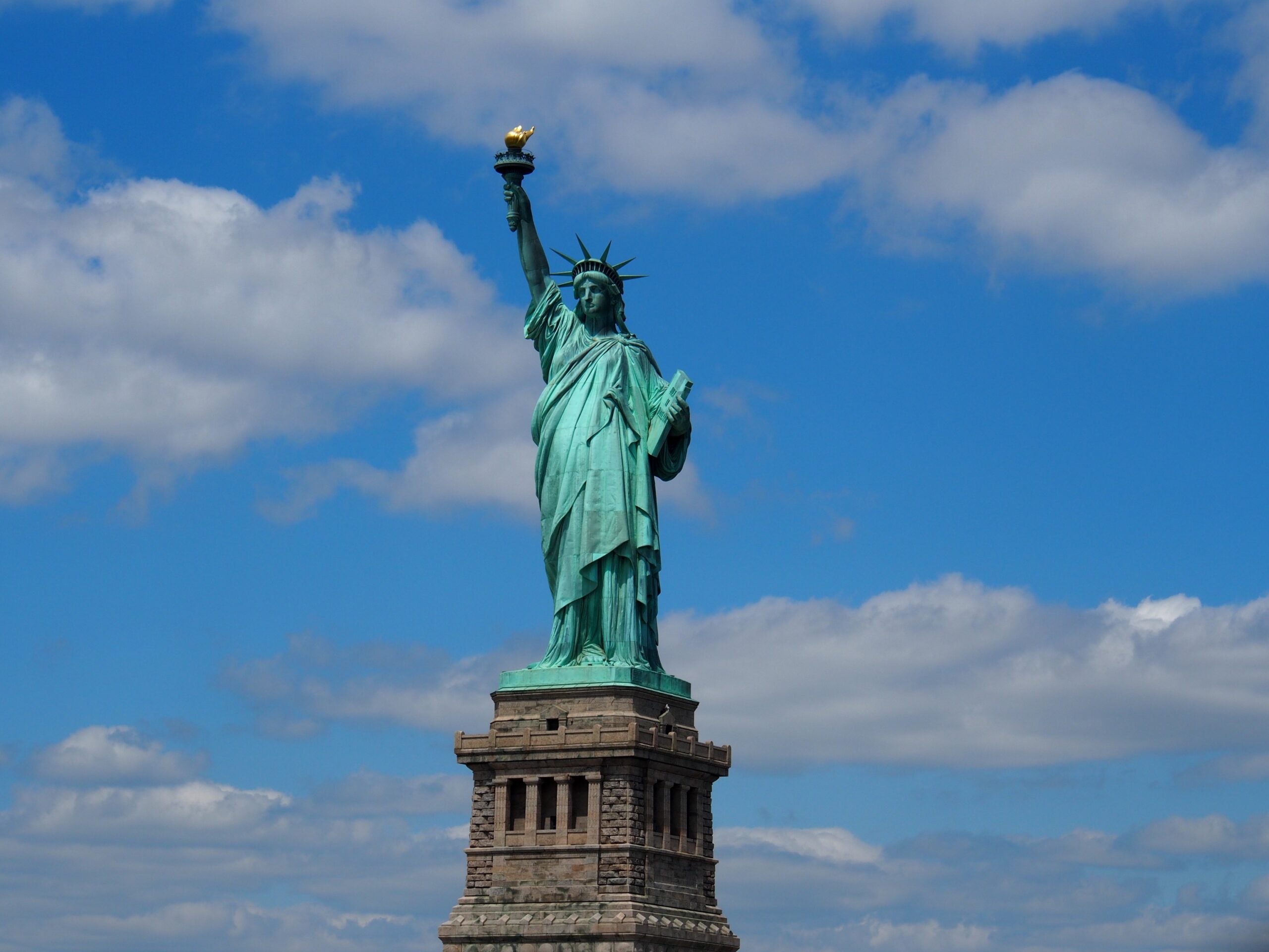 Statue of Liberty against blue sky with clouds