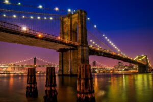 Brooklyn Bridge lit up over the East River at dusk