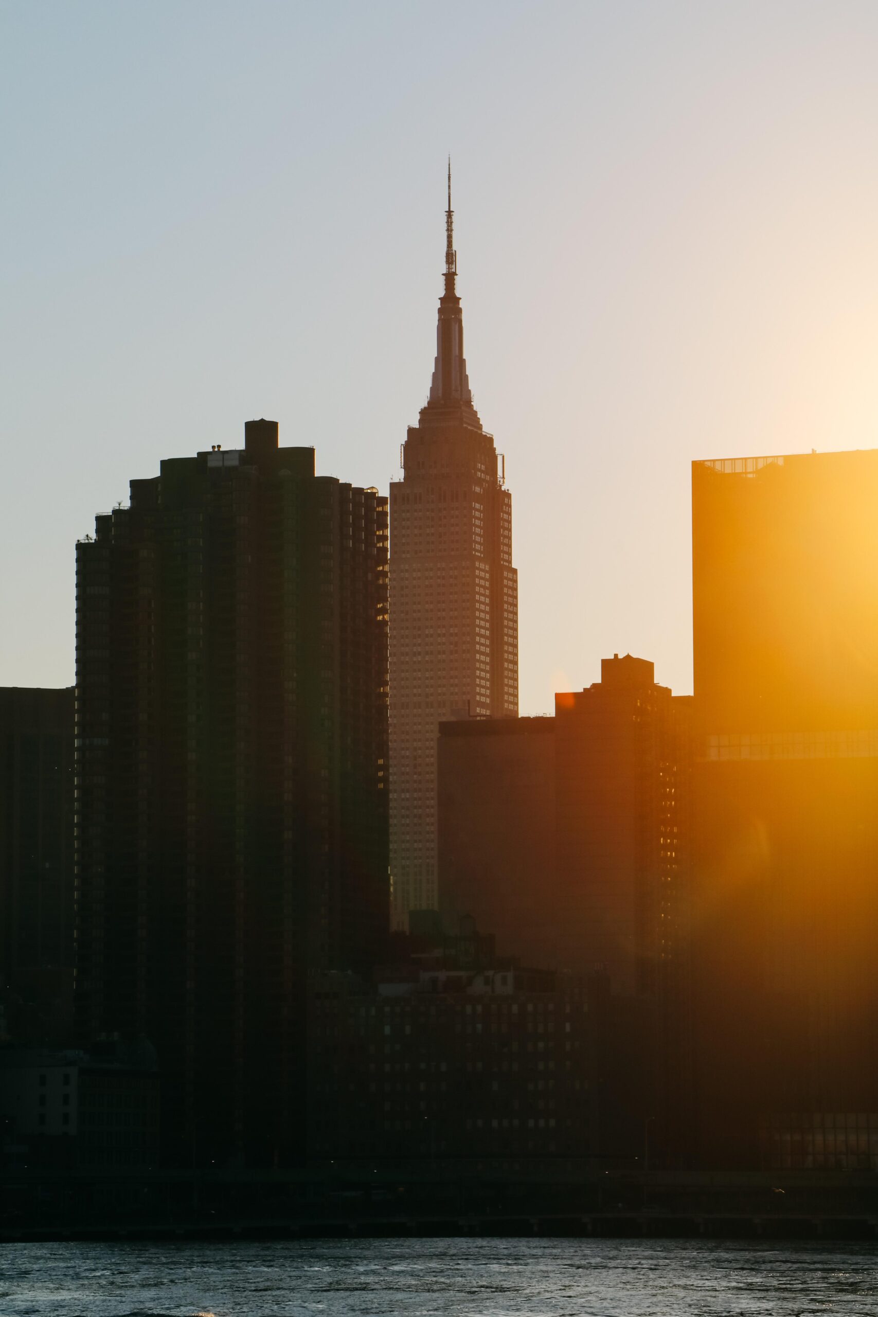 Empire State Building spire glowing above the Manhattan skyline