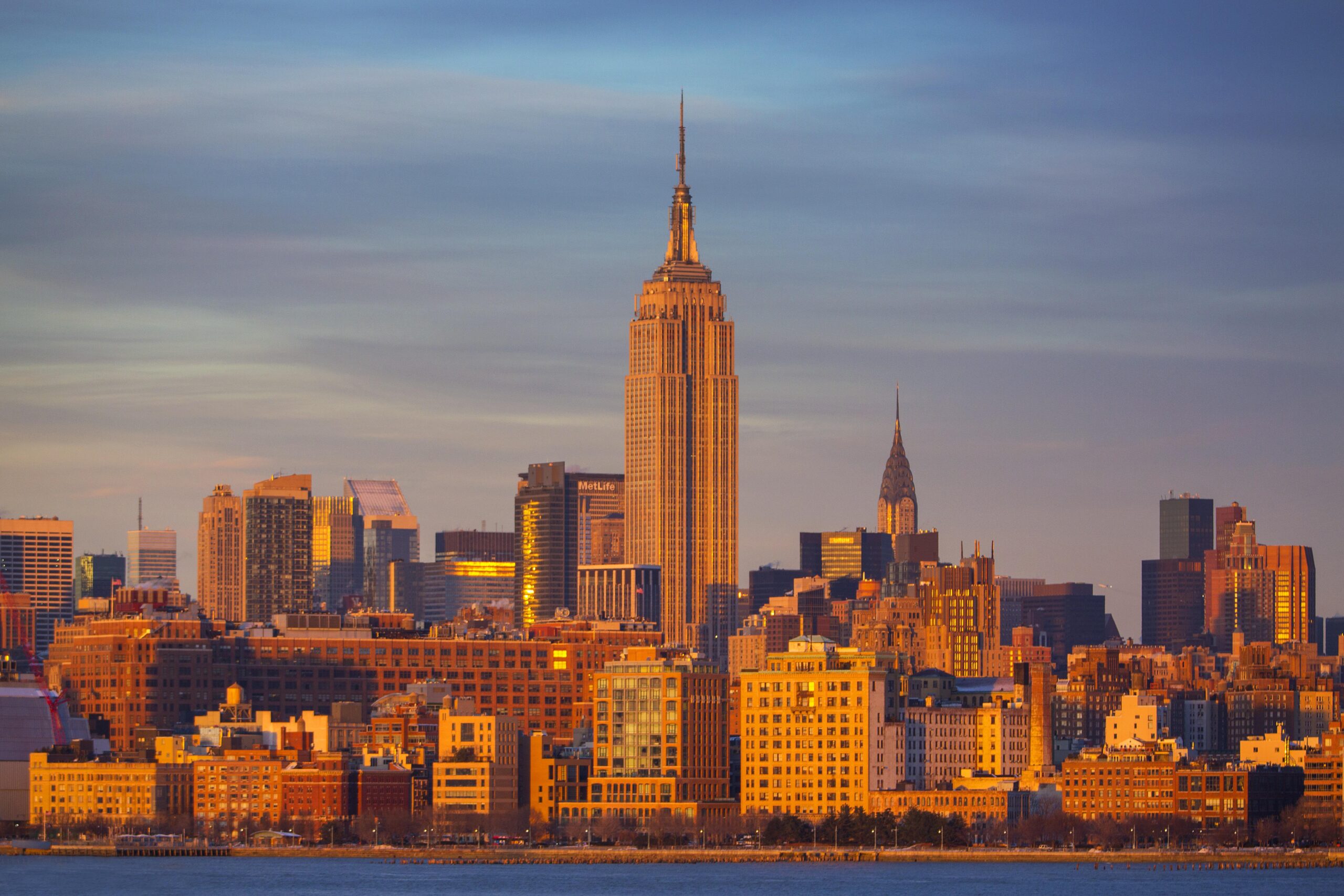 Empire State and Chrysler Buildings lit gold at sunset