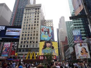 Busy Times Square crowd beneath McDonald's sign and towering billboards