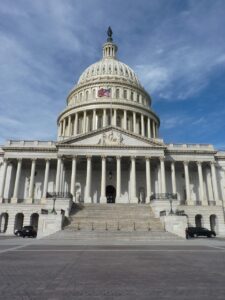 Front of the U.S. Capitol dome and steps under a blue sky