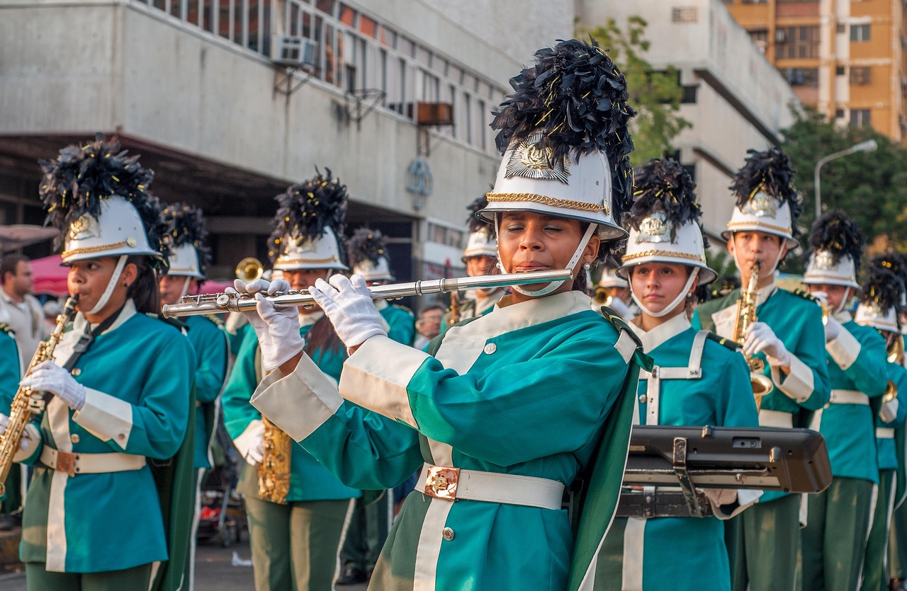 Marching band musicians in teal uniforms playing flute