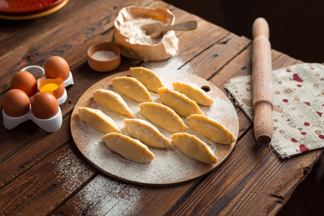 Uncooked dumplings arranged on a floured wooden board