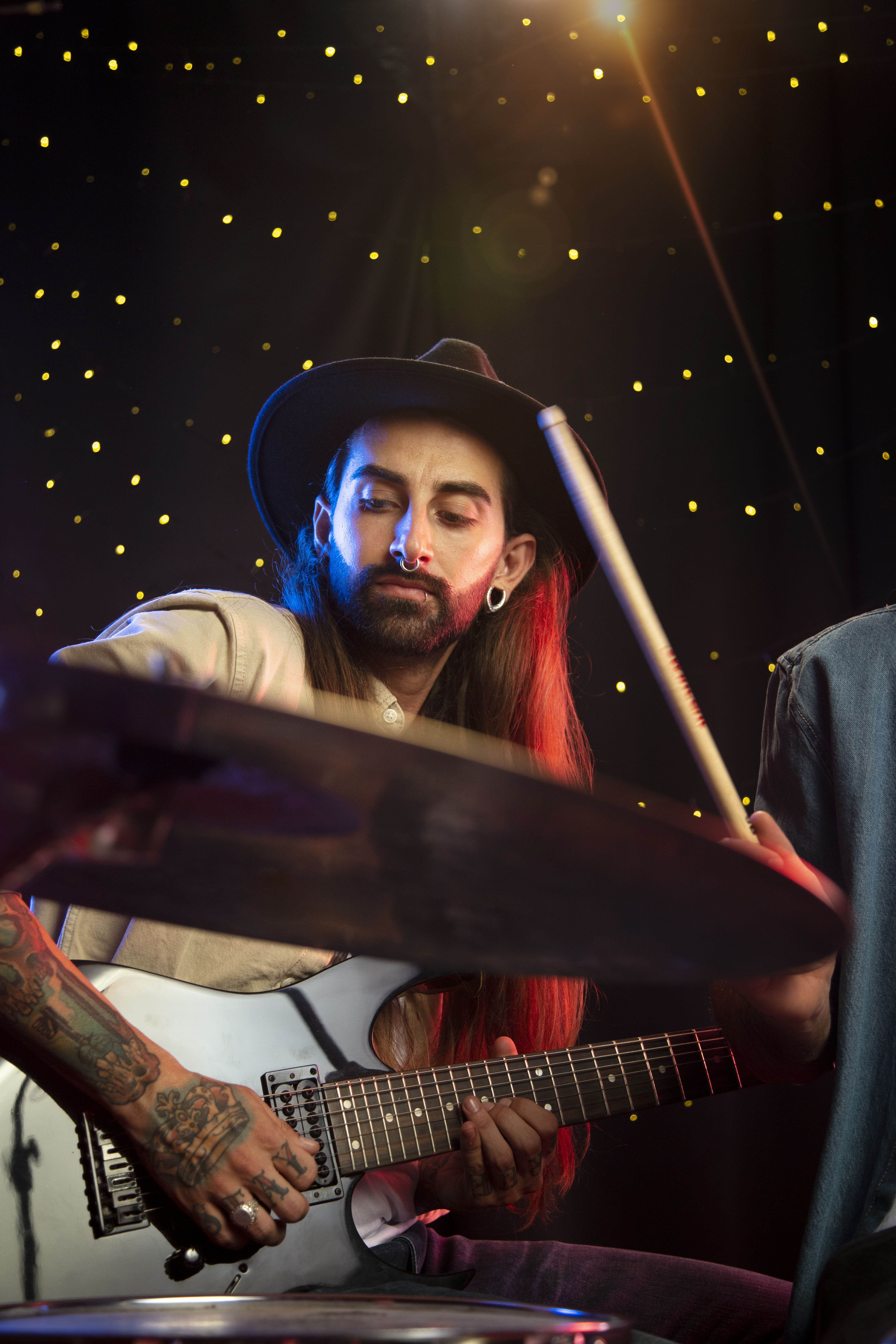 Man playing electric guitar under stage lights.